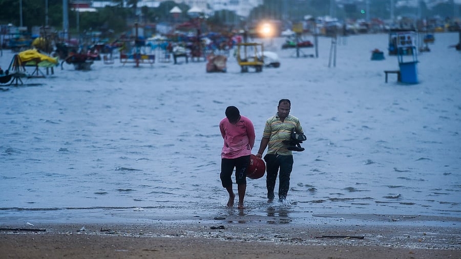 Fishermen move their commodities to a safer place as waves measuring about two to three metres hit the Marina beach owing to the depression in the Bay of Bengal, in Chennai, Thursday. Credit: PTI File Photo