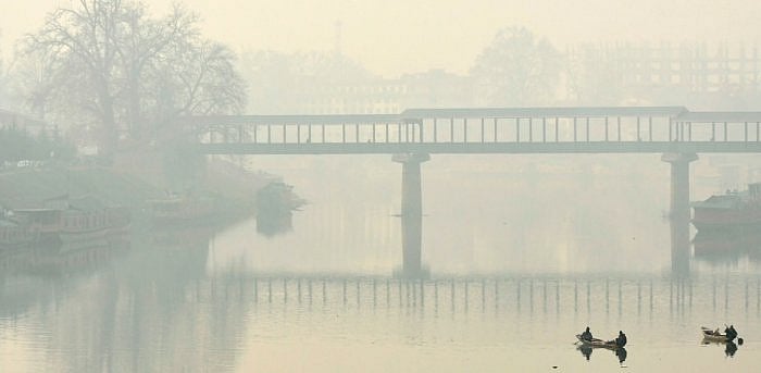 Boatmen row their boats in the waters of river Jhelum amid foggy condition in Srinagar. Credit: AFP File Photo