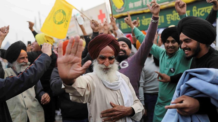 Farmers celebrate after Prime Minister Narendra Modi announced that he will repeal the controversial farm laws, at the Singhu border farmers protest site near Delhi-Haryana border. Credit: Reuters Photo