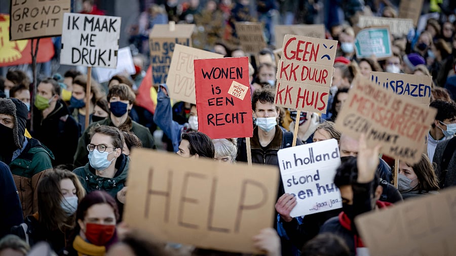 A person holds a placard reading "living is a right" during a protest. Credit: AFP Photo