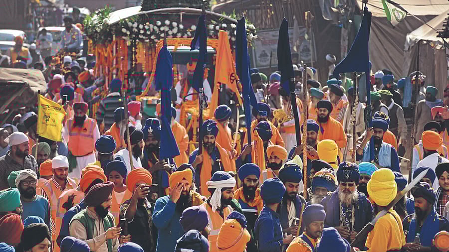 Nihangs and farmers take part in a procession at the Singhu border, one of farmers' agitation sites, in New Delhi. Credit: PTI Photo