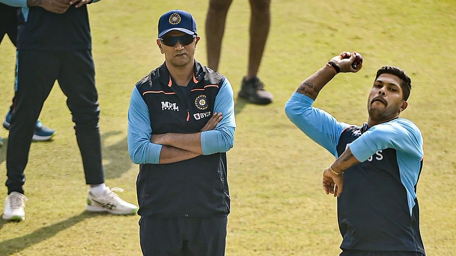 India's Umesh Yadav bowls as coach Rahul Dravid looks on, during a practice session ahead of their first cricket test match against New Zealand, in Kanpur. Credit: PTI Photo