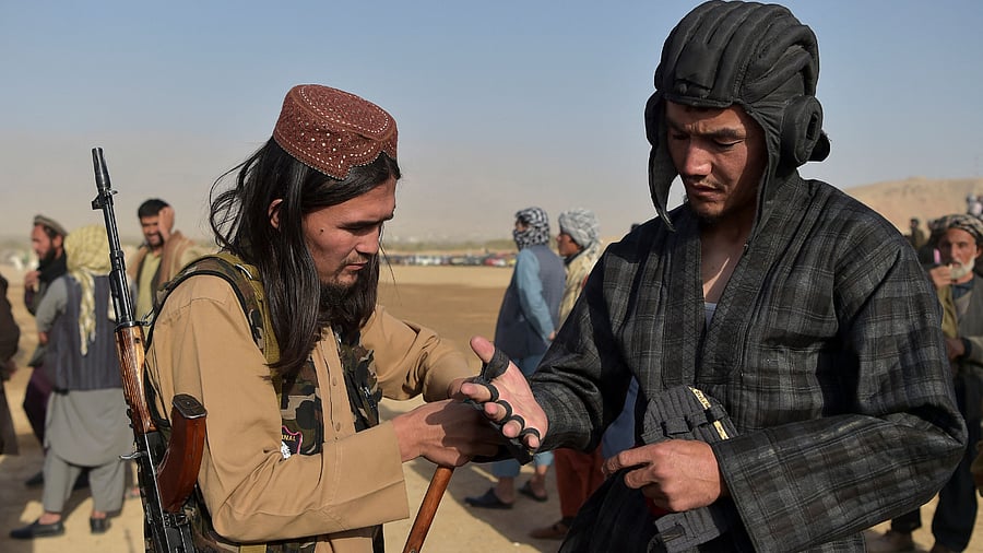 Taliban fighter Osama (L) helping Taliban leader Abu Do Jana. Credit: Reuters Phot