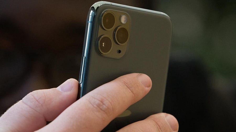 An employee holds an Apple Inc. iPhone 11 Pro smartphone. Credit: Bloomberg Photo