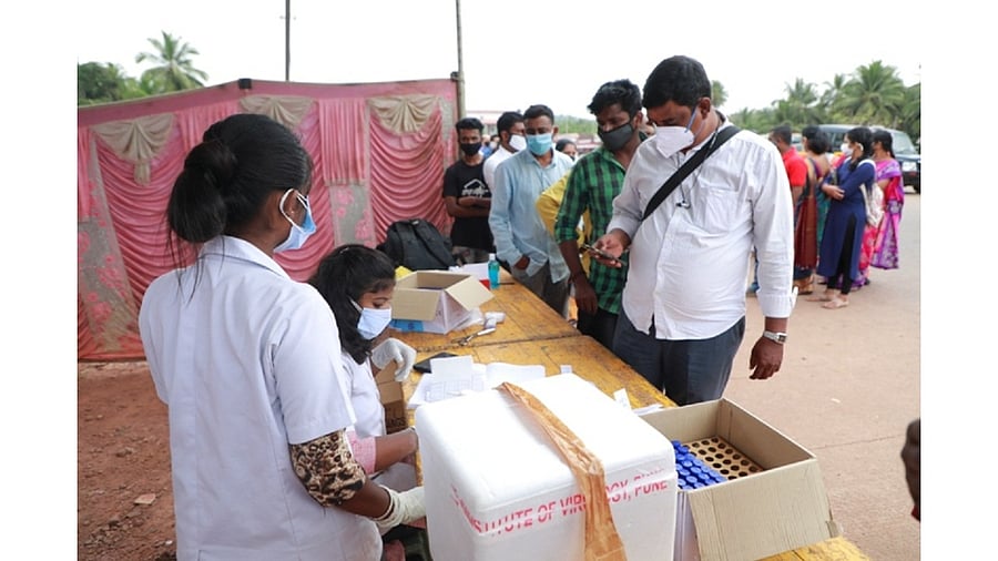 Travellers line up at the Talapady check post at the Karnataka-Kerala border for a Covid-19 test. Credit: DH File Photo