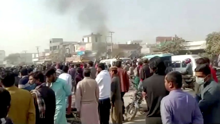 People gather after an attack on a factory in Sialkot, Pakistan December 3, 2021, in this screen grab taken from a video. Credit: Reuters TV via Reuters