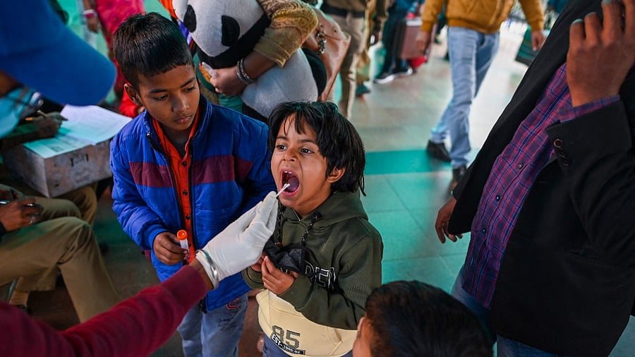 A health worker collects swab samples from a traveller. Credit: AFP Photo