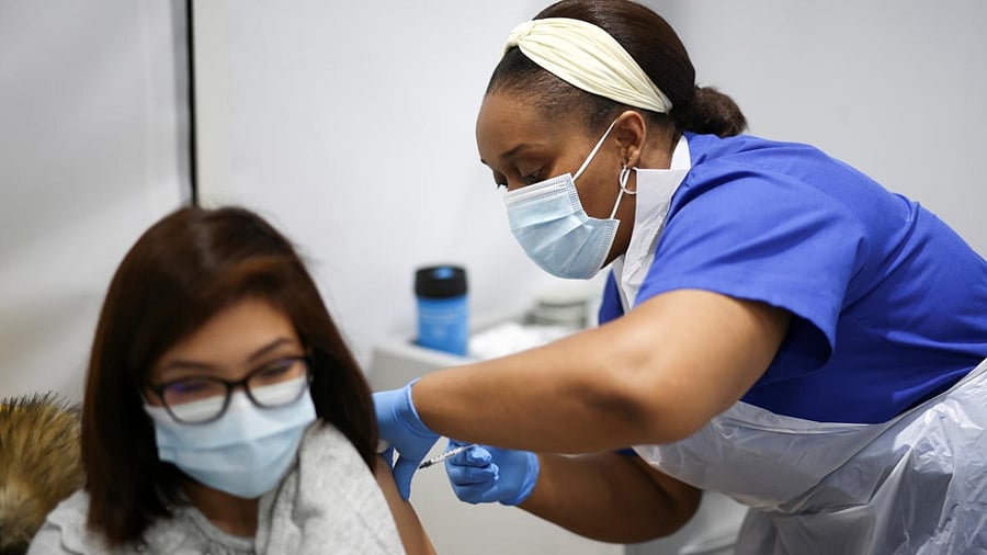 A person receives a dose of the Pfizer coronavirus disease (Covid-19) vaccine at a vaccination site at the Westfield shopping centre in London, Britain. Credit: Reuters Photo