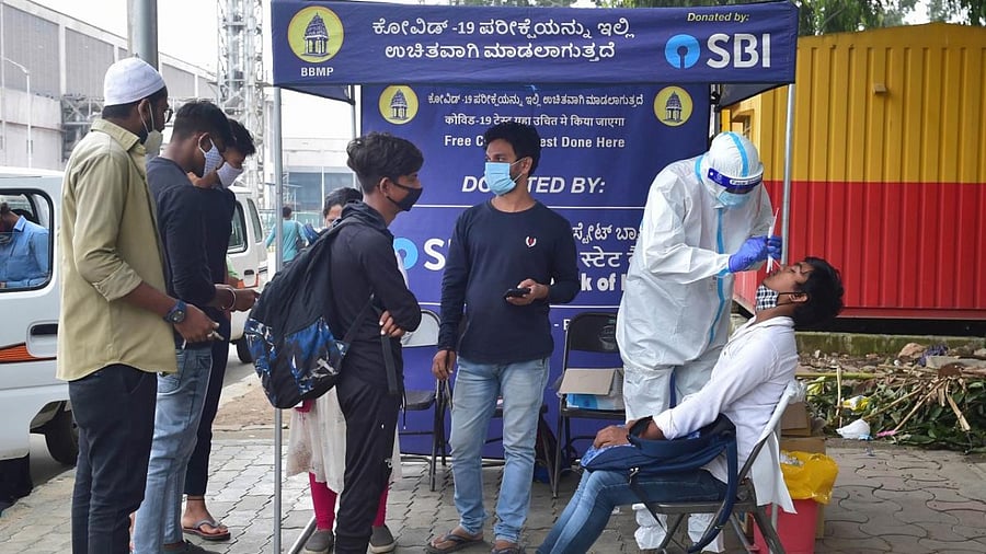 A healthcare worker takes swab sample for Covid-19 tests in Bengaluru. Credit: PTI Photo