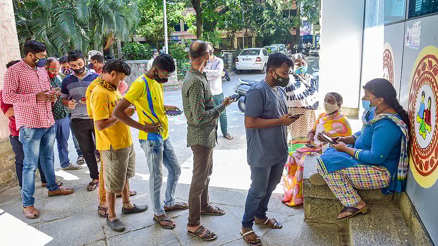 Beneficiaries wait to receive a dose of Covid-19 vaccine at a government hospital amid fear of spread of 'Omicron variant' in Bengaluru. Credit: PTI Photo