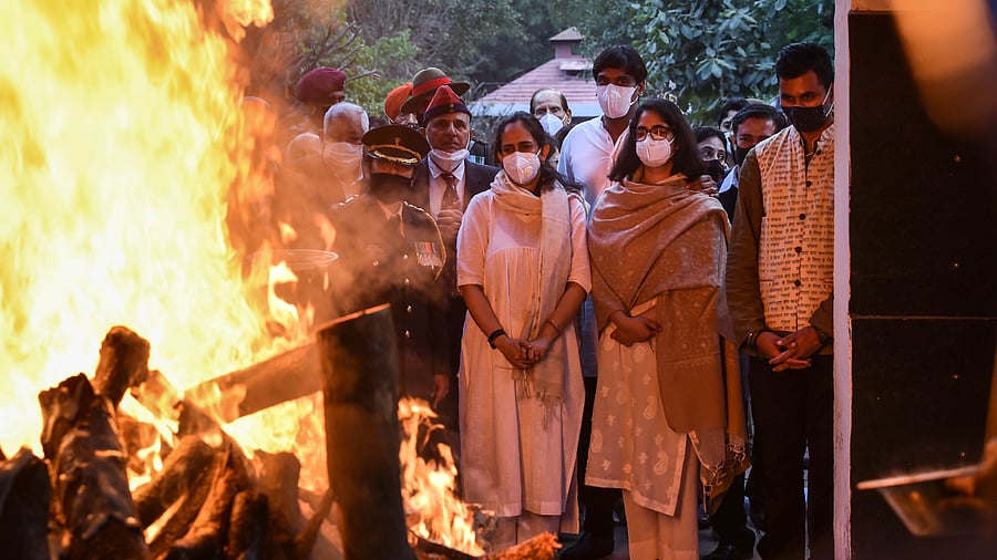 Kritika and Tarini, daughters of late Chief of Defence Staff (CDS) Gen Bipin Rawat and Madhulika Rawat, look on during the cremation of their parents at Brar Square crematorium. Credit: PTI Photo
