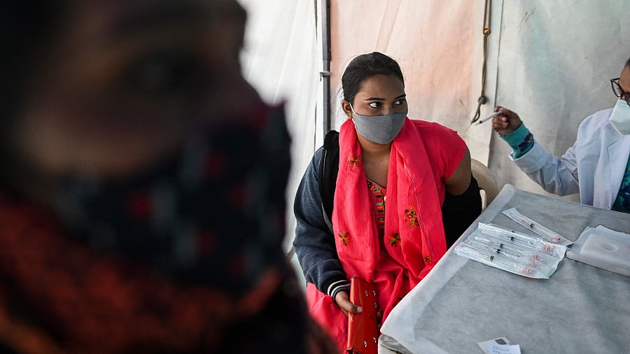 A woman gets herself inoculated with Covishield. Credit: AFP Photo