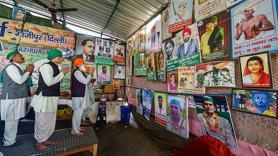 Farmers pay tribute to their leaders as they prepare to leave after a decision to withdraw farmers' movement was taken in the wake of the government accepting all their demands, at Ghazipur border, in New Delhi, Friday. Credit: PTI Photo