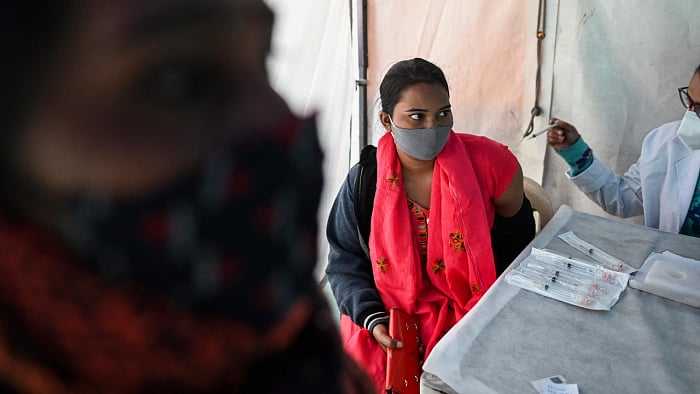 A woman gets herself inoculated with Covishield. Credit: AFP Photo