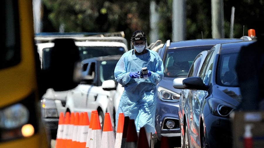 A medical worker performs a PCR test at a drive-through Covid-19 test centre in western Sydney. Credit: AFP Photo