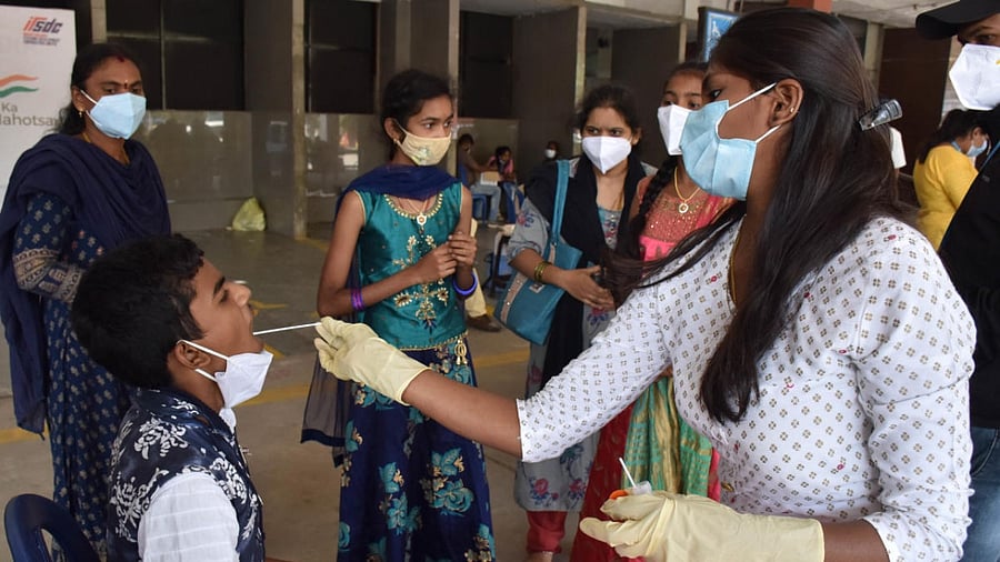 A health worker collecting swab samples in Bengaluru on Monday. Credit:DH Photo/BK Janardhan