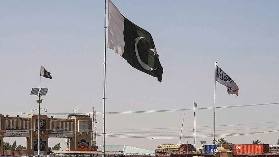 Pakistani flags (C) and Taliban flag (R) flutter on their respective border sides as seen from the Pakistan-Afghanistan border crossing point in Chaman. Credit: AFP Photo