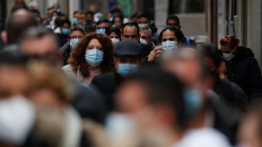 People wearing face masks queue to buy Christmas lottery tickets, in Madrid. Credit: Reuters photo