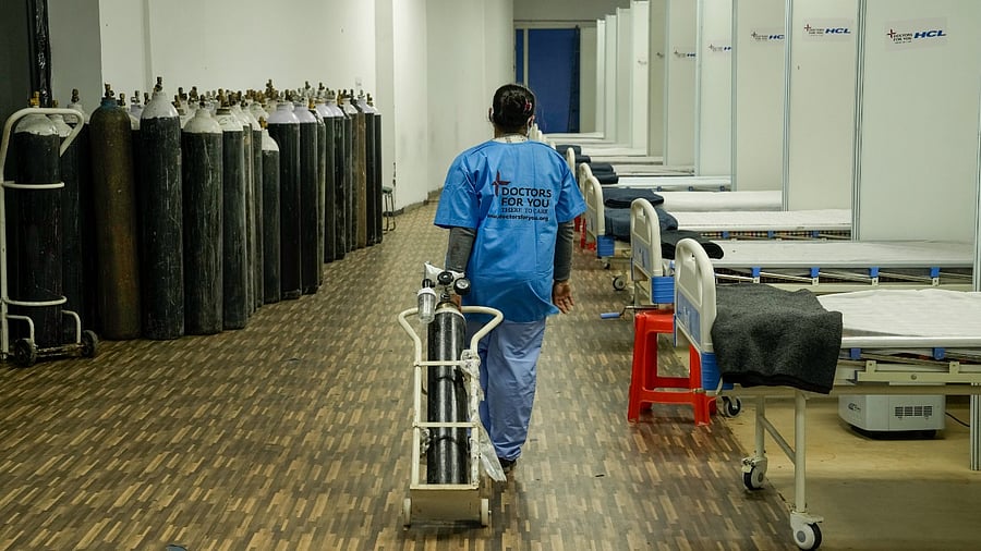 A health worker arranges an oxygen cylinder at a Covid Care Centre, as part of preparedness against the new variant Omicron. Credit: PTI File Photo
