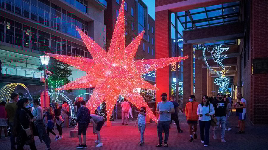 People enjoy Christmas decorations in Melrose Arch, Johannesburg, on December 21, 2021. Credit: AFP Photo