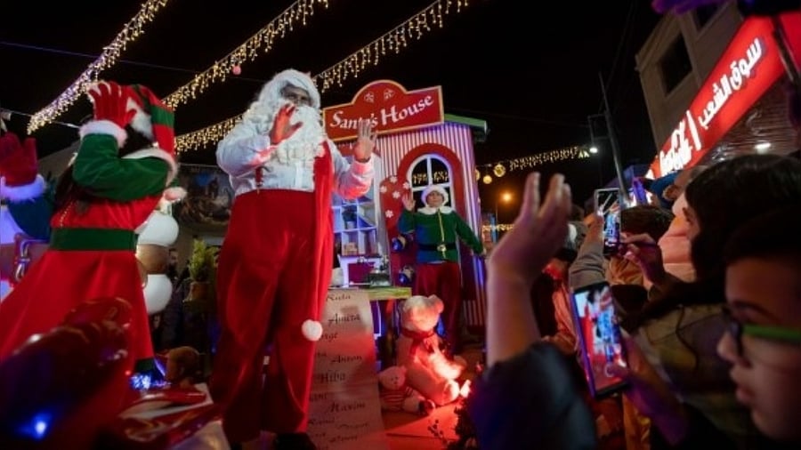 Performers are seen during the annual Christmas caravan parade in the West Bank city of Bethlehem, on Dec. 19, 2021. Credit: IANS Photo