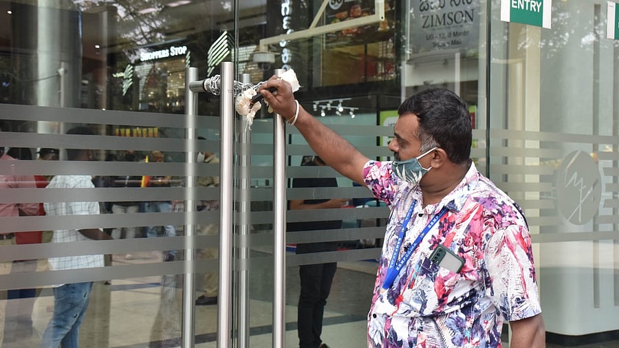 A BBMP official seals Mantri Mall in Bengaluru. Credit: DH File Photo/ B K Janardhan
