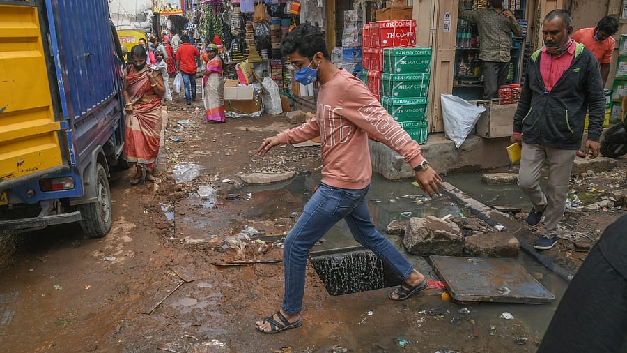 Sewage water overflows from a clogged manhole on the busy Avenue Road. Credit: DH Photo/ S K Dinesh