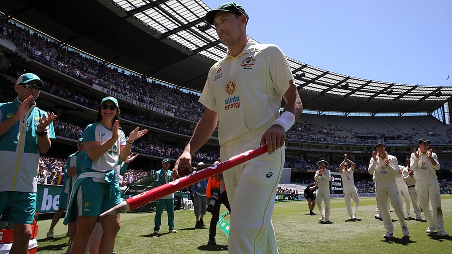 Australia's Scott Boland, center, holds holds a stump after taking 6 wickets against England in their win on the third day of their cricket test match in Melbourne, Australia, Tuesday, December 28, 2021. Credit: AP/PTI Photo