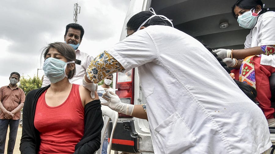A health worker administers a dose of Covid-19 vaccine to a beneficiary, during a mobile vaccination drive by GHMC, at Risala Bazar in Hyderabad. Credit: PTI Photo