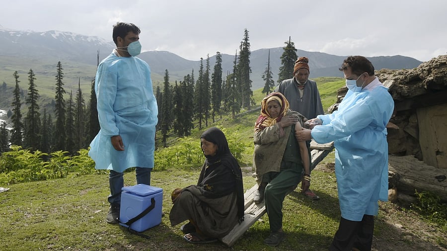 A health worker administers a dose of a Covid-19 vaccine to a woman belonging to Gujjar community during door to door inoculation drive, at Tosamaidan in Budgam district. Credit: PTI Photo