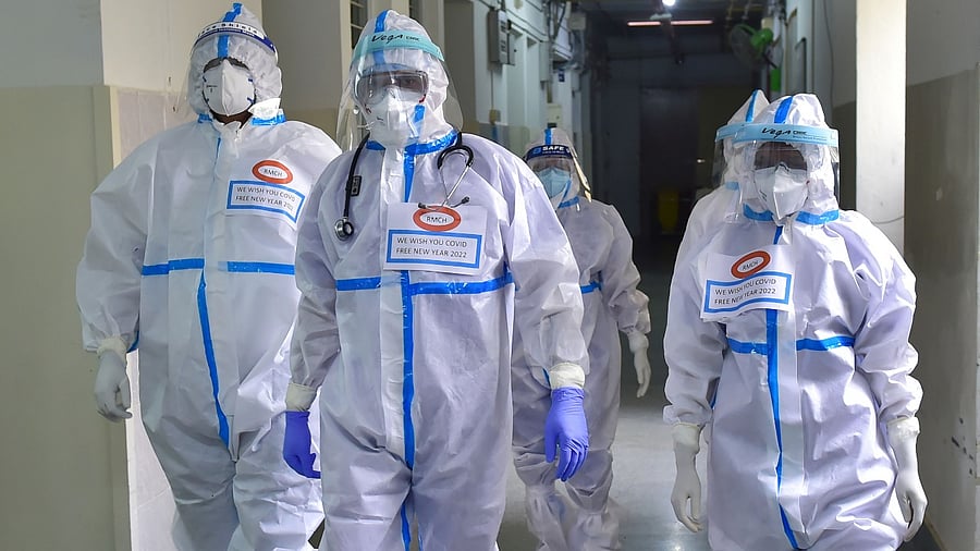 Placards with a message " We wish you Covid free New Year 2022" is seen on the chest of medical staff wearing PPE, inside MS Ramaiah hospital in Bengaluru. Credit: PTI Photo