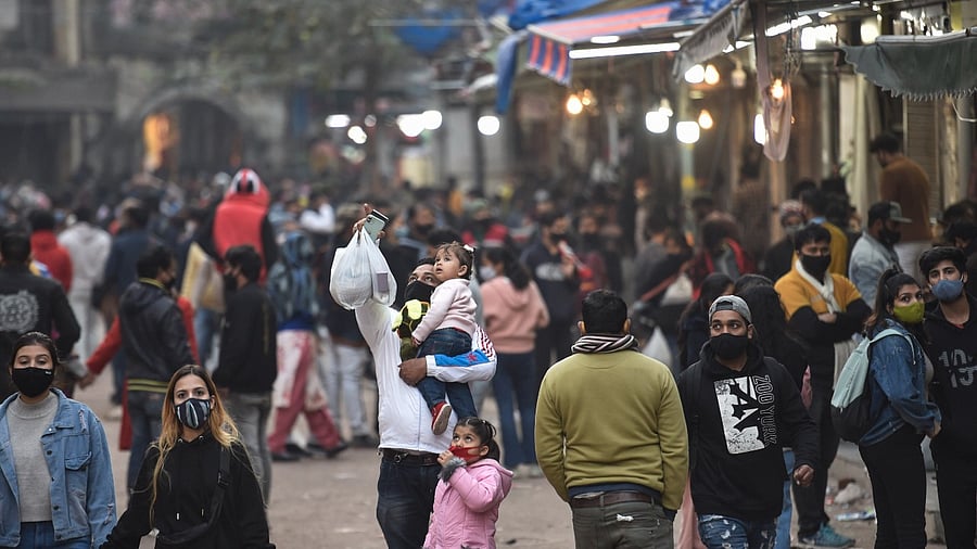 People flout Covid-appropriate behaviour as they visit a crowded Sarojini Market on New Year's eve. Credit: PTI Photo