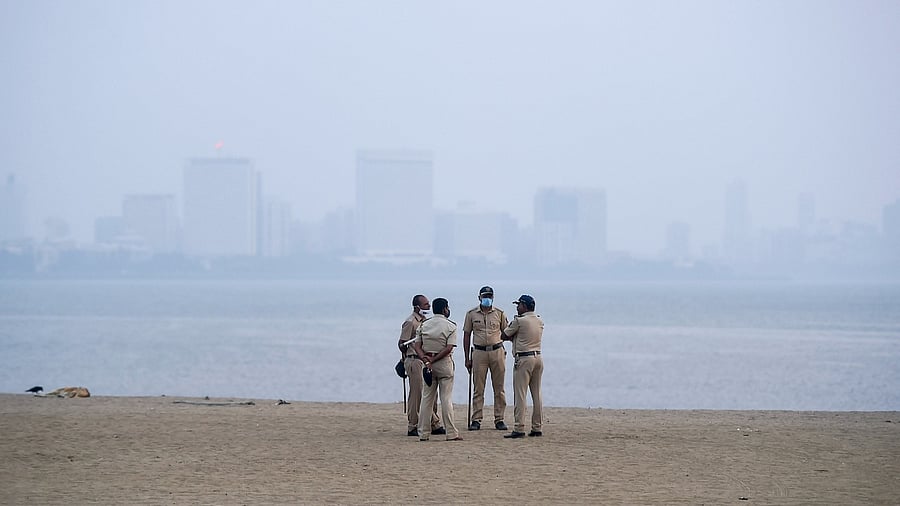 Policeman patrol an empty area of the Girgaum Chowpatty amid restrictions imposed due to rising Covid-19 cases, on New Year's Eve in Mumbai. Credit: PTI Photo