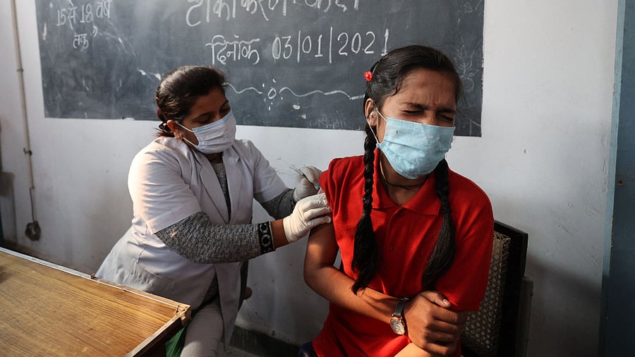 A health worker inoculates a youth with a dose of the Covaxine vaccine against the Covid-19 coronavirus during a vaccination drive for people in the 15-18 age group. Credit: AFP Photo