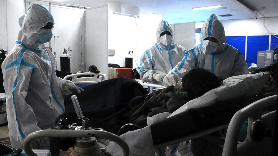 Health workers on a routine check-up of Covid-19 patients at CWG Covid Care Centre in New Delhi. Credit: IANS Photo