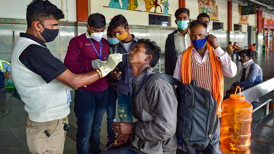 A health worker collects swab sample of a passenger for Covid-19 test, amid fear of spread of the Omicron variant of Covid-19. Credit: PTI Photo