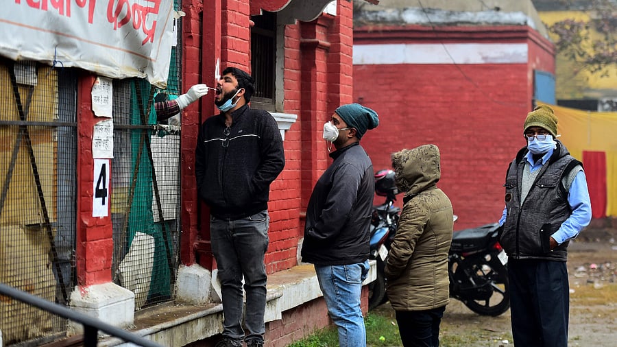 A health worker takes a swab sample from a man for the Covid-19 coronavirus screening at a testing centre in Allahabad. Credit: AFP Photo
