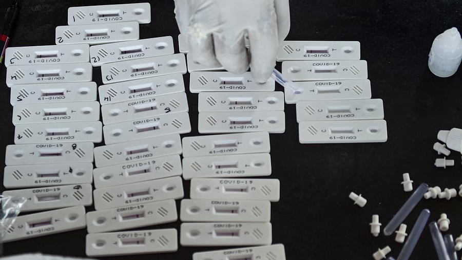 A BMC health worker conducts Covid-19 tests on samples taken from outstation passengers, at Dadar railway station in Mumbai. Credit: PTI Photo