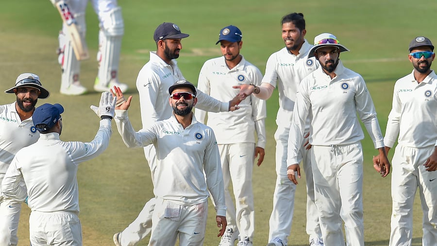 Indian bowler Umesh Yadav (3rd R) and Virat Kohli celebrate the wicket of West Indies captain Jason Holder. Credit: PTI Photo