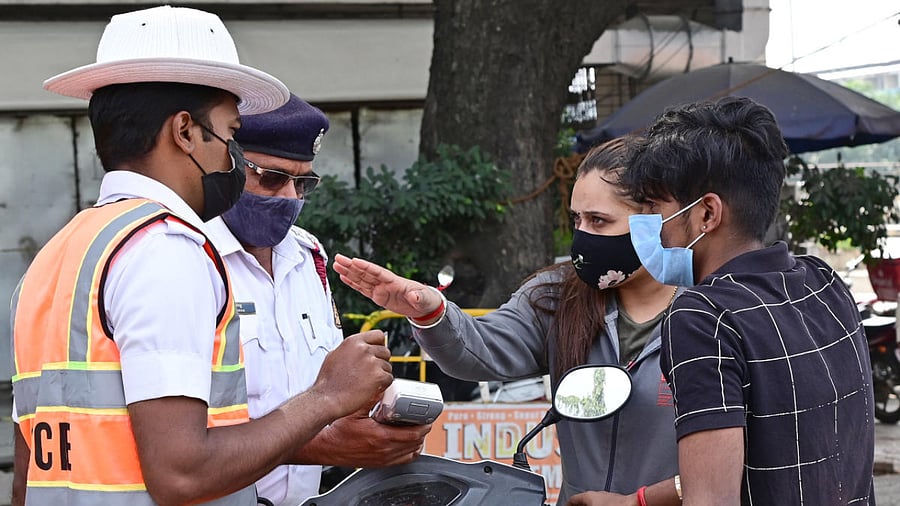 Police check vehicles for violating the weekend curfew near the Mysuru Road bus station on Saturday. Credit: DH Photo