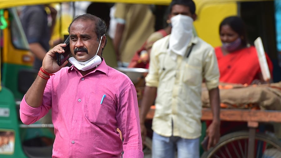A man speaks on the phone as he crosses a road in Bengaluru. Credit: PTI Photo