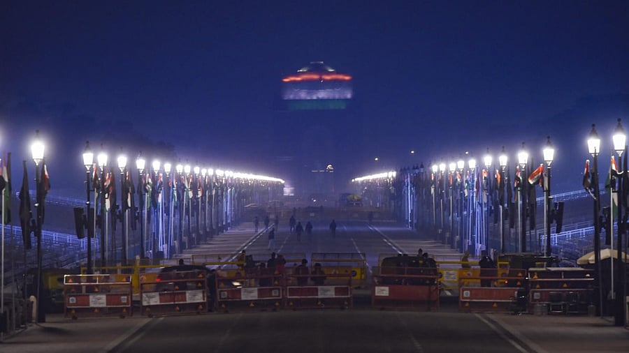 Security personnel stand guard near a barricade at Rajpath, on the eve of the Republic Day 2022 Parade in New Delhi. Credit: PTI Photo