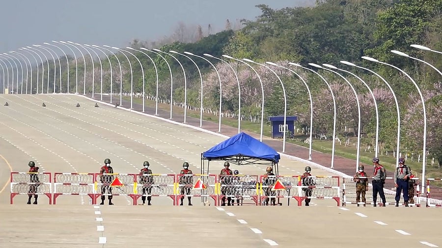 In this file photo taken on February 1, 2021, soldiers stand guard on a blockaded road to Myanmar's parliament in Naypyidaw, after the military detained the country's de facto leader Aung San Suu Kyi and the country's president in a coup. Credit: AFP File Photo