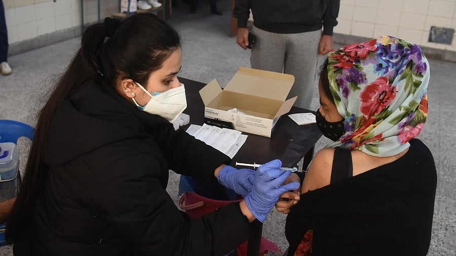  A health worker administers a dose of Covid-19 vaccine to a beneficiary at Laxmi Nagar in New Delhi. Credit: IANS 