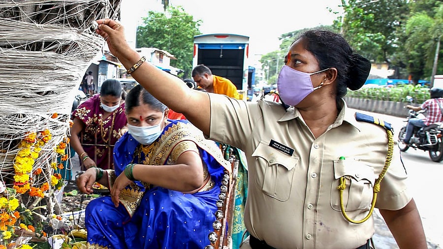 A Mumbai police woman ties a thread around a Banyan tree. Credit: PTI File Photo