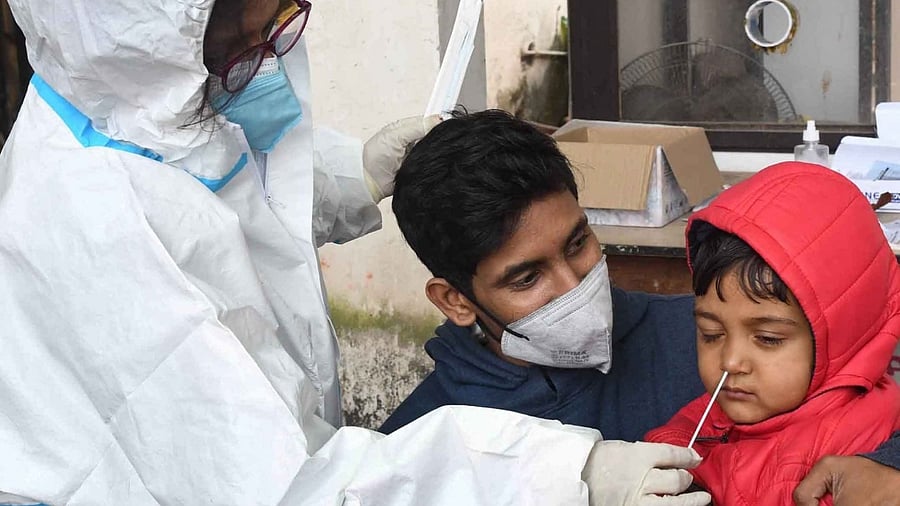 A health worker takes swb sample from a child for Covid-19 test at Gardiner Hospital in Patna on Thursday January 27, 2022. Credit: IANS File Photo