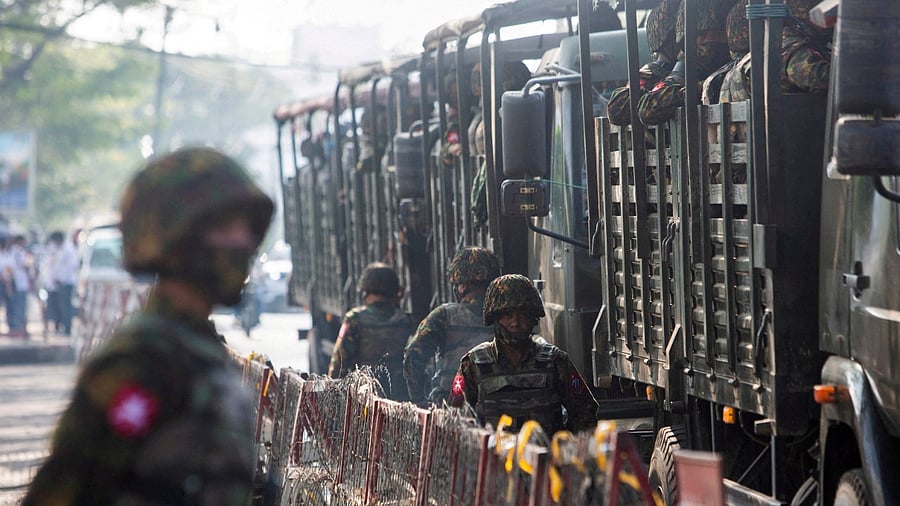 Soldiers stand next to military vehicles as people gather to protest against the military coup, in Yangon. Credit: Reuters File photo