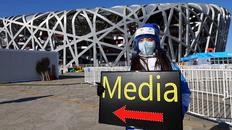 A volunteer holds a sign for members of the media in front of the stadium before the opening ceremony. Credit: Reuters File Photo