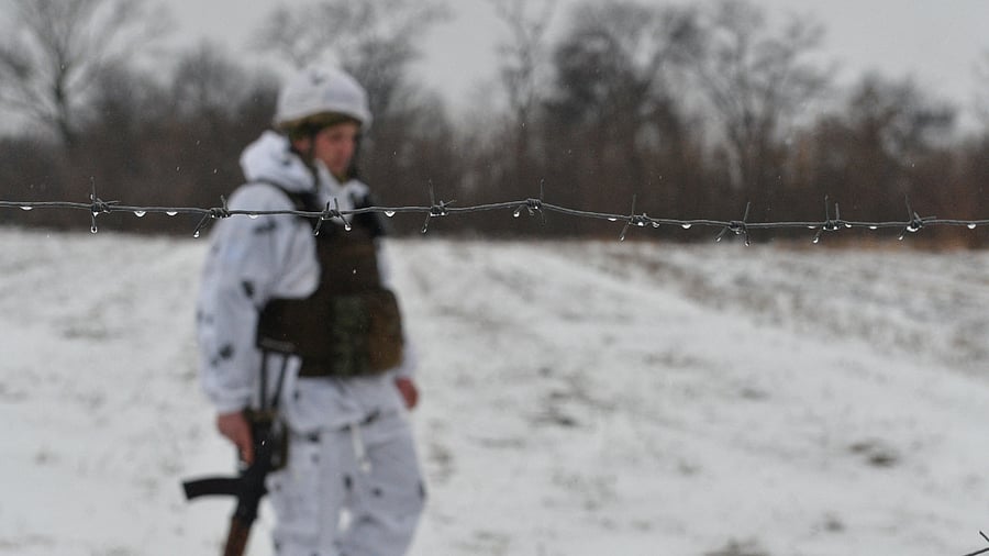 A service member of the Ukrainian armed forces is seen behind a barbed wire at combat positions in Donetsk region. Credit: Reuters Photo