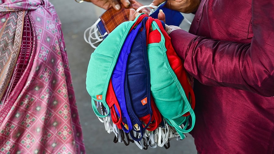 A vendor sells face masks amid fear of spread of a new variant of Covid-19, at K R Market in Bengaluru. Credit: PTI Photo